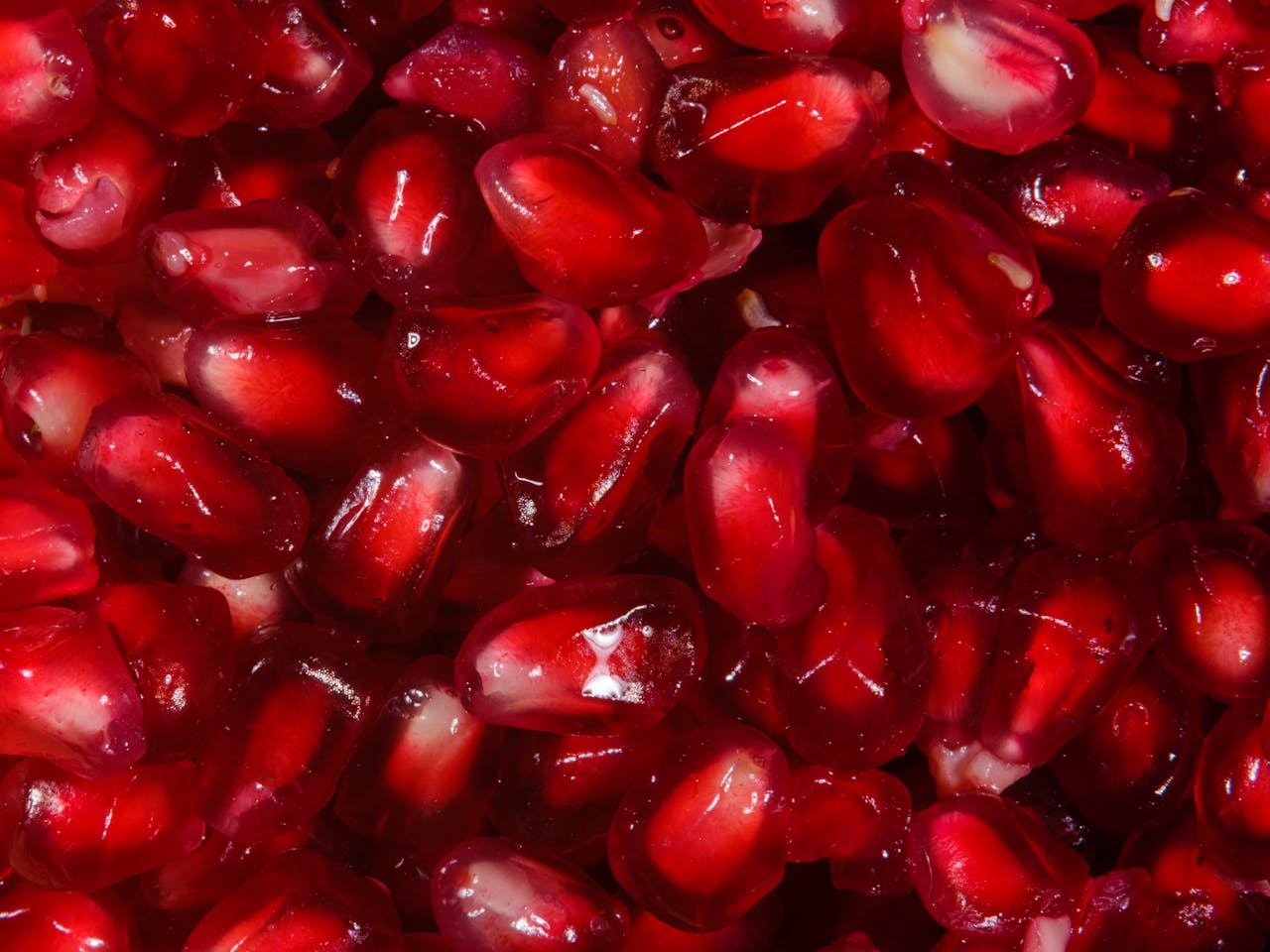 Delicious and juicy pomegranate seeds in a detailed close-up perfect for healthy food concepts.