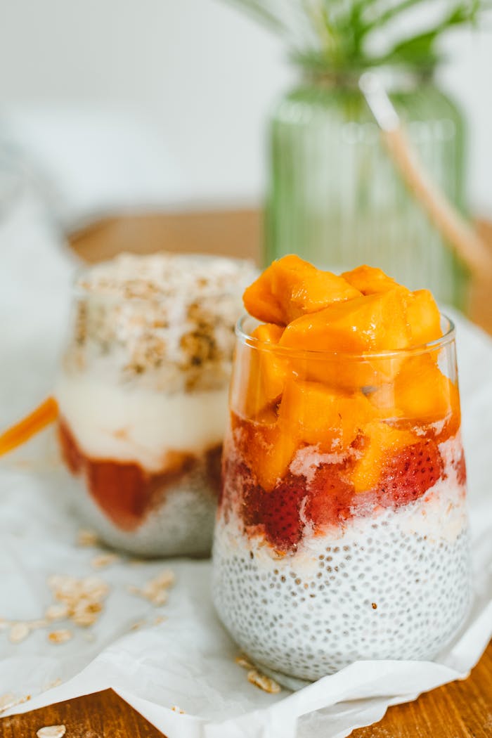 A close-up of creamy chia pudding topped with fresh mango and strawberries, showcasing a healthy dessert option.